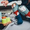 A toddler in animal print pajama pants plays with a toy